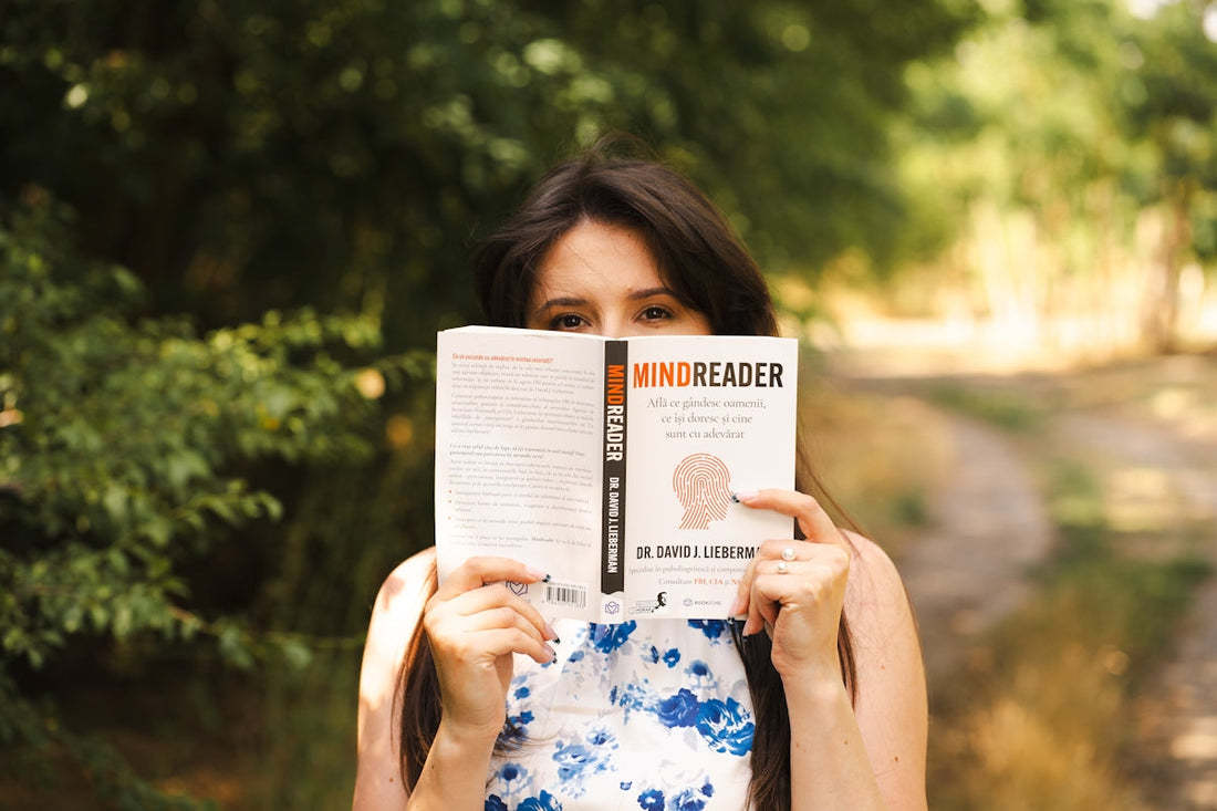 Woman holds a book titled mindreader.
