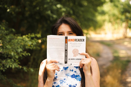 Woman holds a book titled mindreader.