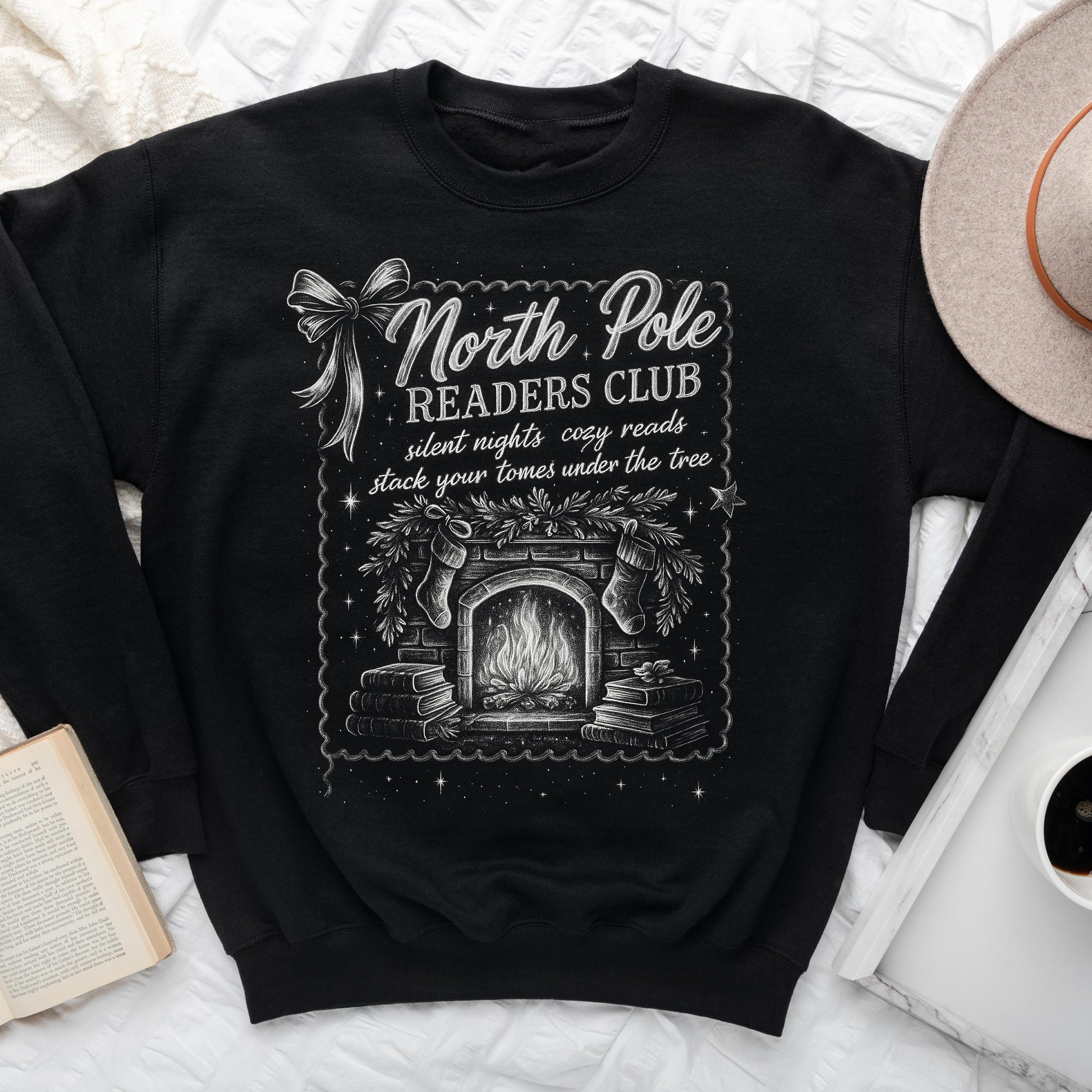 Black Christmas sweatshirt with vintage-style North Pole Readers Club design featuring a fireplace, stockings, books, and holiday accents