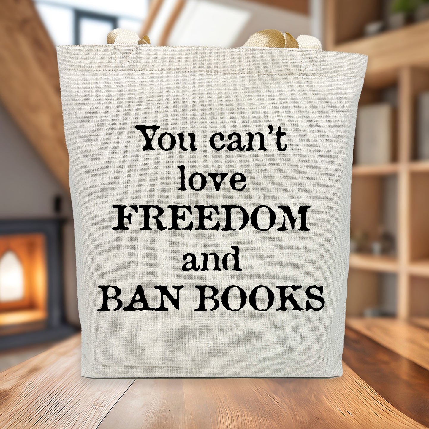 Tote bag with text 'You can't love freedom and ban books' on a wooden surface.