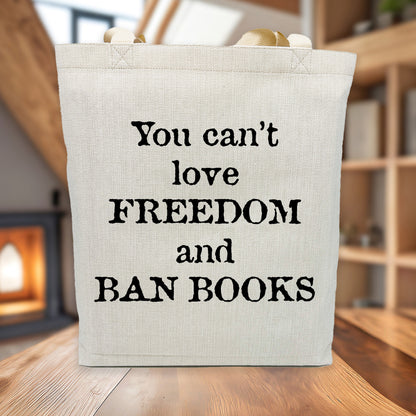 Tote bag with text 'You can't love freedom and ban books' on a wooden surface.