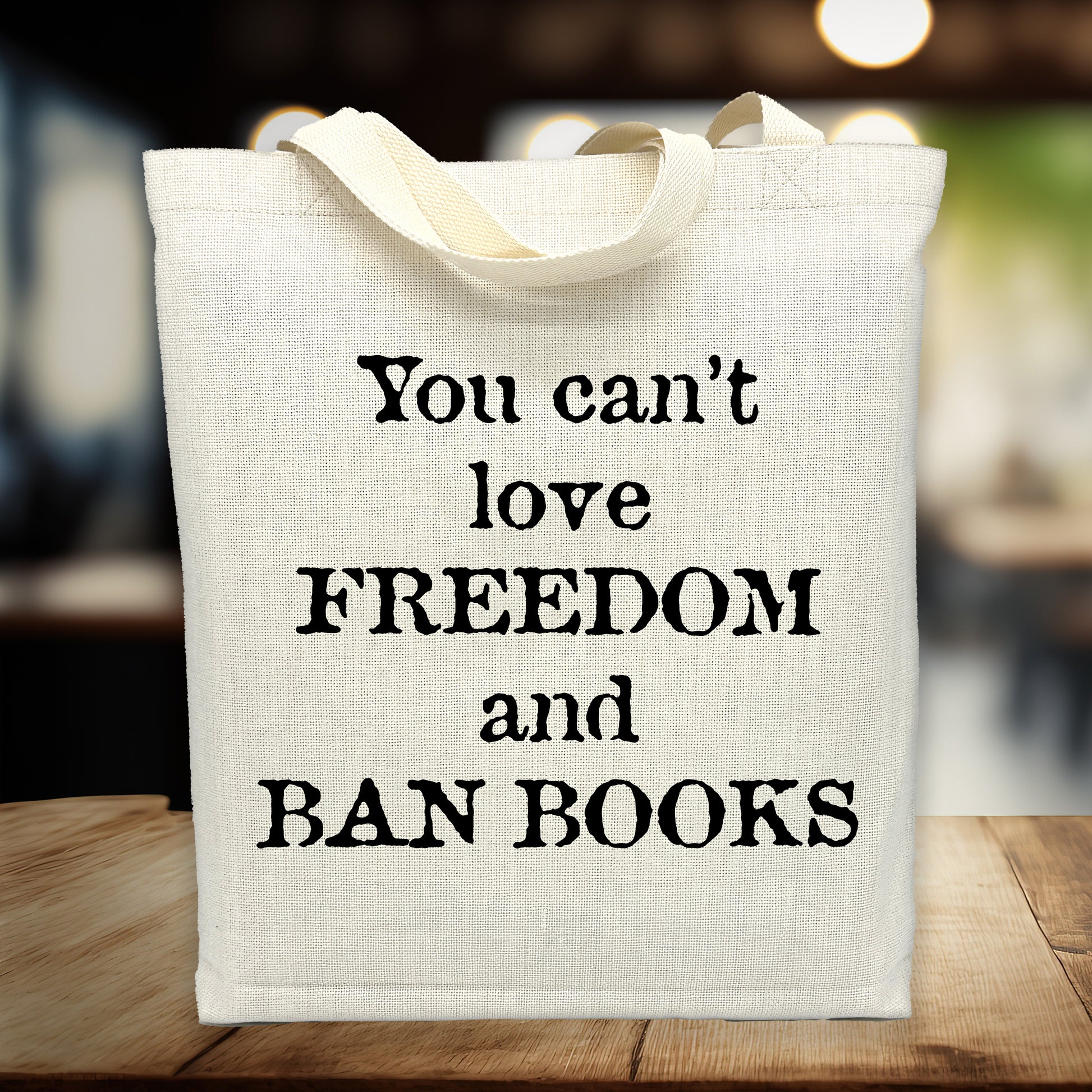 Tote bag with text 'You can't love freedom and ban books' on a blurred background