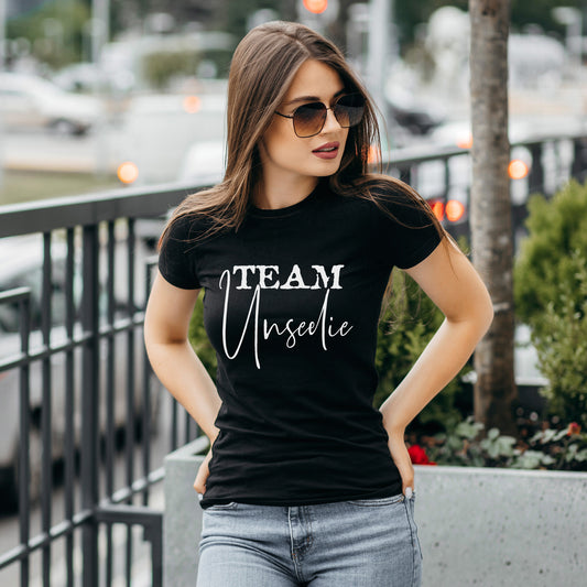 Woman wearing a Team Unseelie black t-shirt about a dark fae book theme